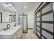 Modern bathroom with double sinks, a glass-enclosed shower, and elegant black and white accents at 430 Capri Isles Ct, Punta Gorda, FL 33950