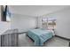 Simple bedroom with light gray walls and decor, featuring a tv, dresser and street view at 430 Capri Isles Ct, Punta Gorda, FL 33950