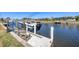 View of canal with boat on lift, chairs on the dock and waterfront homes in the neighborhood at 430 Capri Isles Ct, Punta Gorda, FL 33950
