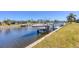 Beautiful waterfront view showing boat on lift, seawall and landscaping of the properties at 430 Capri Isles Ct, Punta Gorda, FL 33950