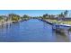 Wide canal view of multiple waterfront homes with docks and boats lifts on a sunny day at 430 Capri Isles Ct, Punta Gorda, FL 33950