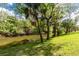 Waterfront backyard with mature trees and lush greenery at 4818 Kiska Rd, North Port, FL 34288