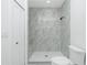 Bathroom with a marble tiled shower, a built-in bench, sleek fixtures, and white honeycomb flooring at 4818 Kiska Rd, North Port, FL 34288