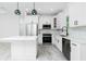 Bright kitchen with stainless steel appliances, modern white cabinetry, and a spacious island with seating at 4818 Kiska Rd, North Port, FL 34288