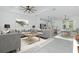 Open-concept living room flowing into a modern kitchen and dining area with stylish gray furniture at 4818 Kiska Rd, North Port, FL 34288