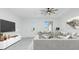 Bright living room featuring gray sofas, modern decor, a ceiling fan, and an art piece on the wall at 4818 Kiska Rd, North Port, FL 34288