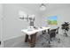 Bright office space featuring a large desk, office chairs, modern art, and a view through the window at 4818 Kiska Rd, North Port, FL 34288