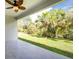 Covered patio overlooking a lush green yard with tropical landscaping, complete with a ceiling fan at 4818 Kiska Rd, North Port, FL 34288