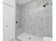 Beautiful white tiled shower with shower niche and seamless glass door at 4818 Kiska Rd, North Port, FL 34288