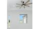 A view of a neighboring house and blue skies through a window with white trim and a ceiling fan above at 4818 Kiska Rd, North Port, FL 34288