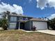 Two story home with a two car garage and a well manicured lawn on a sunny day at 4948 Cromey Rd, North Port, FL 34288