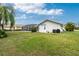 Exterior view of the home's backyard and screened-in pool with green lawn at 51 Amazon Dr, Punta Gorda, FL 33983