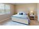 Bright bedroom with a king bed, side tables, and large window with blinds allowing natural light to fill the space at 565 Mistiflower Cir, Nokomis, FL 34275