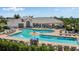 Community pool with comfortable seating, umbrellas and clubhouse nearby at 565 Mistiflower Cir, Nokomis, FL 34275