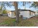 View of backyard with house, landscaping, and tree providing shade at 6534 29Th N Way, St Petersburg, FL 33702