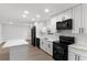 Contemporary kitchen boasts white cabinets, black appliances and an open layout at 6534 29Th N Way, St Petersburg, FL 33702