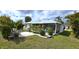 A bright, white home boasts a screened-in lanai and lush, tropical landscaping in the private backyard at 7534 Carissa, Punta Gorda, FL 33955