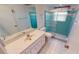 Bathroom featuring a shower with sliding glass doors, toilet, sink, and white tile flooring at 7534 Carissa, Punta Gorda, FL 33955