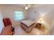 Cozy bedroom with tile floors, ceiling fan, window, bed, and side table with lamp at 7534 Carissa, Punta Gorda, FL 33955