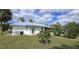 Home exterior featuring well-maintained lawn and mature landscaping at 7534 Carissa, Punta Gorda, FL 33955