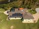Aerial view highlighting the modern home with solar panels and the private screened pool at 9149 Lane Ct, Port Charlotte, FL 33981