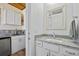 A full bathroom with marble counters and white cabinets adjacent to the kitchenette at 9149 Lane Ct, Port Charlotte, FL 33981