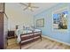 Bedroom with blue accent wall features a ceiling fan and plenty of natural light at 9149 Lane Ct, Port Charlotte, FL 33981