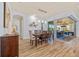 Bright dining room with wood floors, a modern light fixture, and sliding glass doors to the outdoor area at 9149 Lane Ct, Port Charlotte, FL 33981