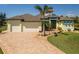Lovely Florida home with a three-car garage, well-manicured lawn, and brick driveway at 9149 Lane Ct, Port Charlotte, FL 33981