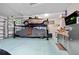Spacious garage equipped with car lift, cabinets, storage, and TV at 9149 Lane Ct, Port Charlotte, FL 33981