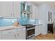 Stylish kitchen with a stainless steel gas range, white cabinets, and blue backsplash at 9149 Lane Ct, Port Charlotte, FL 33981