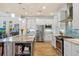 Modern kitchen featuring an island, stainless steel appliances, white cabinetry, and blue backsplash at 9149 Lane Ct, Port Charlotte, FL 33981