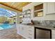 Outdoor kitchenette overlooking the pool and offering stainless mini-fridge and marble counters at 9149 Lane Ct, Port Charlotte, FL 33981