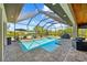Sparkling screened-in pool area with an outdoor grill, and inviting seating with backyard views at 9149 Lane Ct, Port Charlotte, FL 33981