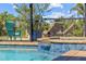 Close up of pool with a small waterfall feature, blue tile detail, and outdoor lounge chairs at 9149 Lane Ct, Port Charlotte, FL 33981