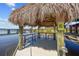 Inviting Tiki bar at the end of a dock features seating and beautiful water views at 9149 Lane Ct, Port Charlotte, FL 33981