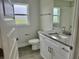 Bathroom featuring granite countertop, white cabinets, and a window for natural light at 9171 Waldrep St, Port Charlotte, FL 33981