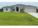 Inviting single-story home featuring a well-manicured lawn and a two-car garage at 9171 Waldrep St, Port Charlotte, FL 33981
