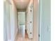 Hallway featuring neutral walls, wood-look flooring, and white doors leading to various rooms at 9171 Waldrep St, Port Charlotte, FL 33981