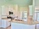 Bright kitchen with white cabinets, granite countertops, stainless steel appliances and open view at 9171 Waldrep St, Port Charlotte, FL 33981