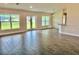 Open-concept living room with wood-look tile flooring, large windows, and recessed lighting at 9171 Waldrep St, Port Charlotte, FL 33981