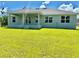 Expansive backyard featuring a covered patio, lush green lawn, and beautiful landscaping, perfect for outdoor living at 9590 Little Rock St, Port Charlotte, FL 33981