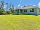 Wide backyard featuring a covered patio, lush green lawn, with room for outdoor recreation and entertaining at 9590 Little Rock St, Port Charlotte, FL 33981