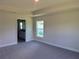 Inviting bedroom with neutral tones, plush carpeting, and natural light streaming through the window at 9590 Little Rock St, Port Charlotte, FL 33981