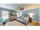 This bedroom features light blue walls, wood floors, a ceiling fan, and a decorative bed frame at 10052 Winding River Rd, Punta Gorda, FL 33950