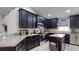 Modern kitchen with dark cabinetry, granite countertops, stainless steel appliances, and ample counter space at 10052 Winding River Rd, Punta Gorda, FL 33950