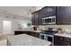 Modern kitchen featuring granite counters, dark cabinets, and stainless steel appliances at 10052 Winding River Rd, Punta Gorda, FL 33950