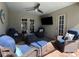 Screened-in patio featuring outdoor ceiling fan and wicker furniture with blue cushions at 10052 Winding River Rd, Punta Gorda, FL 33950