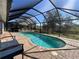 A screened-in pool features a brick patio, sun loungers, and a relaxing outdoor space at 10052 Winding River Rd, Punta Gorda, FL 33950