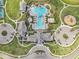 Overhead view of a community clubhouse with pools, tennis courts, and playground, showcasing recreational facilities at 10112 Canaveral Cir, Sarasota, FL 34241